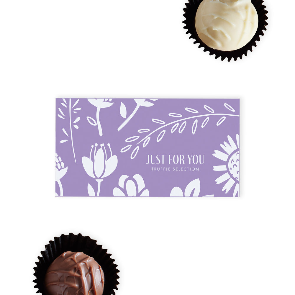  "Just For You" Chocolate Gift Ballotin, a thoughtful and elegant present that's perfect for expressing care and affection.  This charming lilac and white box is adorned with an attractive flower pattern and features the heartfelt words "Just for You" on the lid, setting the tone for the thoughtful gift inside.  Within the box, discover a selection of two hand-finished truffles, one in creamy milk chocolate and the other in luxurious white chocolate